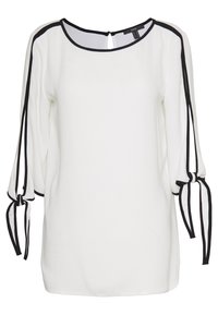 Blouse blanche avec des accents noirs, présentant des manches trois-quarts avec des nœuds, un col rond et une ouverture en goutte d'eau au dos. Texture de tissu lisse.