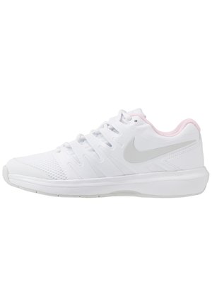 Baskets de sport blanches avec embout en mesh, doublure intérieure rose clair et un swoosh Nike gris sur le côté, vues de l’extérieur.