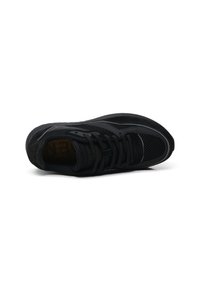 Scarpa sportiva nera con tomaia in rete e dettagli in camoscio, punta arrotondata e suola testurizzata, progettata per traspirabilità e comfort.
