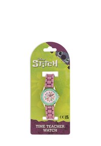 Lila Gummiband-Uhr mit einer grünen Lünette und einem pinken Zifferblatt, das Cartoon-Figuren zeigt. Verpackt auf einer bunten Karte mit der Aufschrift "Time Teacher Watch".