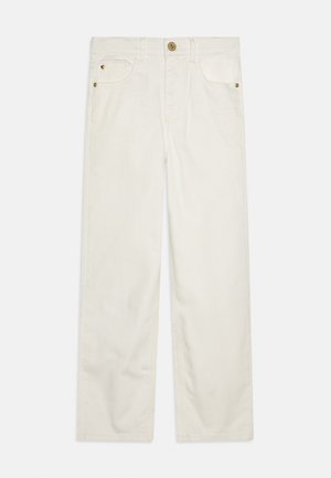 Hvide jeans med lige ben, forlommer, bæltestropper og knaplukning, lagt fladt på en hvid baggrund.