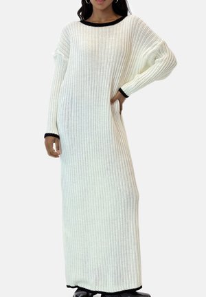 Langes, weißes, geripptes Strickkleid mit schwarzem Besatz am Ausschnitt und an den Bündchen. Das Kleid hat eine lockere Passform und lange Ärmel und reicht bis zu den Knöcheln.