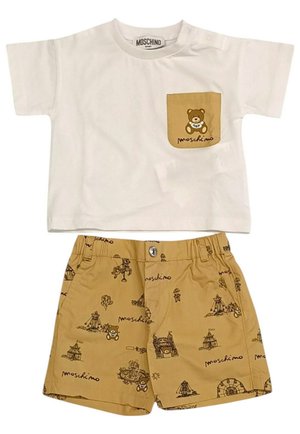 T-shirt bianca in cotone con tasca a forma di orso marrone. Pantaloni corti abbinati in color marrone con disegni neri fantasiosi e chiusura a scatto frontale.