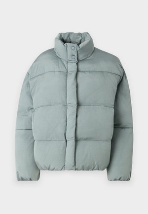 Veste matelassée vert clair avec col montant, fermetures à pression et texture matelassée horizontale. Tissu doux, coupe légèrement surdimensionnée.