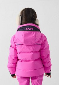 Chaqueta acolchada de color rosa brillante con capucha, con detalles en negro y logotipo en la parte trasera. Material texturizado con diseño acolchado, combinada con guantes negros.