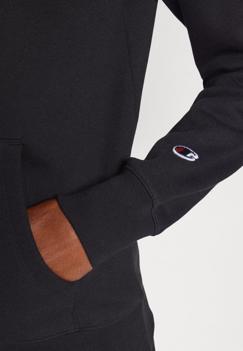 Sudadera nera in misto cotone, con tasca a marsupio, polsini a costine e logo ricamato sulla manica, dal texture morbido.