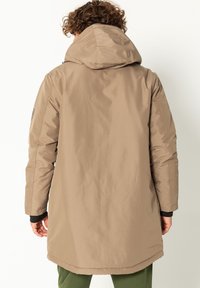 Beige wasserfester Parka mit Kapuze, langen Ärmeln und glatter Textur. Die Rückansicht zeigt einen leicht gebogenen Saum und elastische Bündchen.
