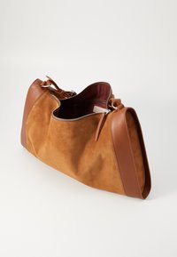 Grand sac fourre-tout en daim marron avec des accents en cuir, une fermeture éclair et une doublure intérieure bordeaux. Équipé de quincaillerie robuste et de poignées.