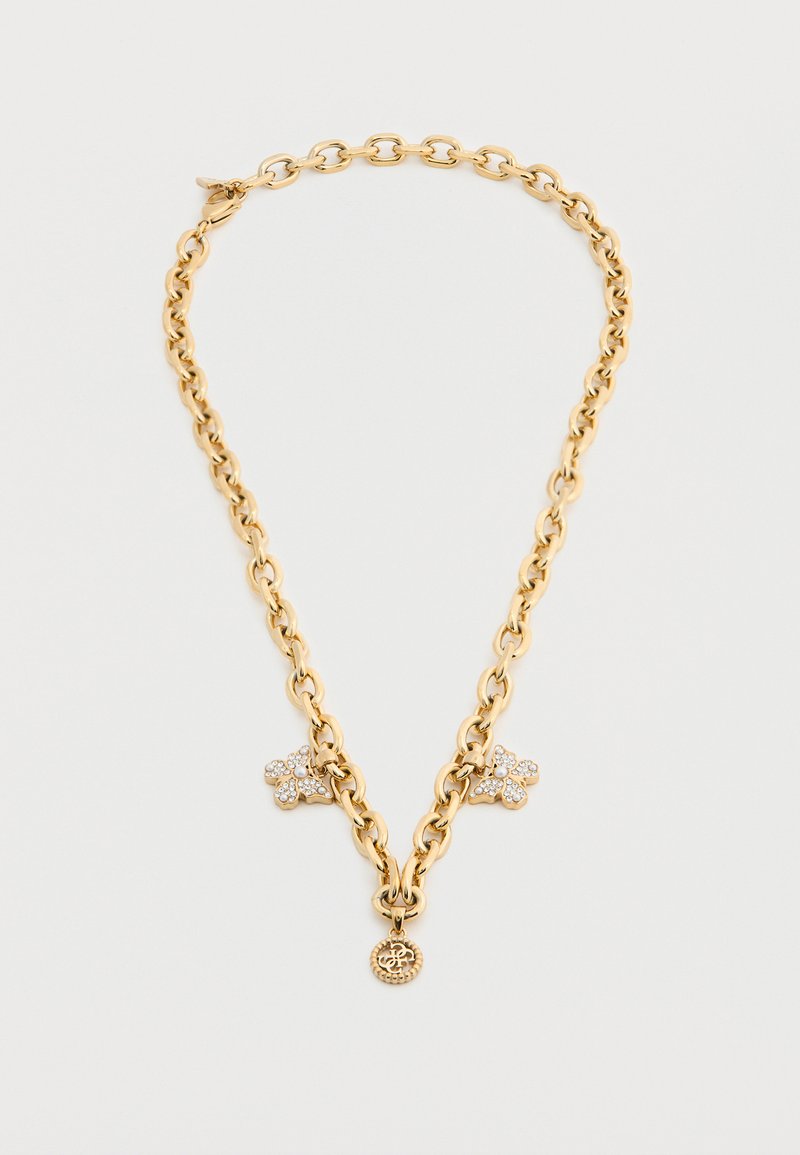 Χρυσό κολιέ αλυσίδα με δύο λουλούδια στολισμένα με κρυστάλλους και ένα μικρό στρογγυλό μενταγιόν με μονόγραμμα.