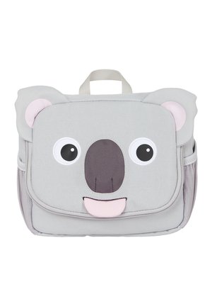 Ein grauer, koala-inspirierter Rucksack mit großen Augen, einer runden Nase und herausgestreckter Zunge. Weicher Stoff mit rosa Ohrakzenten und einem Tragegriff oben.