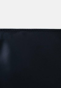 Tissu noir avec une texture lisse, présentant un point soigné le long du bord supérieur, créant un aspect propre et fini.