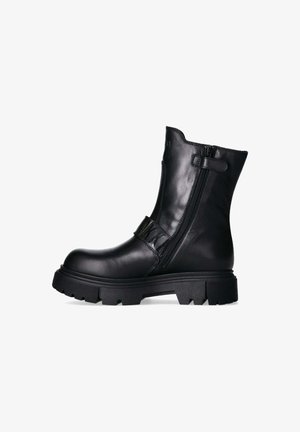 Stivale alla caviglia in pelle nera con suola in gomma spessa, zip laterale e dettaglio con cinturino. Presenta una texture liscia e una punta arrotondata.