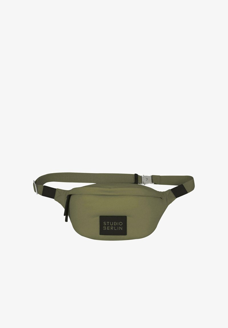Olive green waist bag made of soft material, featuring a black logo patch, adjustable strap, and zippered front pocket.
