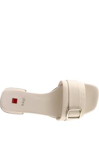 Sandale beige à enfiler avec une boucle carrée sur la bride et un petit talon plat, vue de dessus.