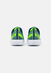 Baskets de sport bleu marine et vert avec une tige en maille, motifs texturés et semelles blanches, dotées d'une languette à l'arrière et d'une marque sur les côtés.