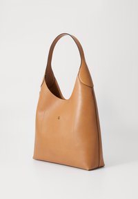 Schoudertas van goudbruin leer met een gebogen handvat, gladde textuur, minimalistisch ontwerp en een voorvak met subtiele stiksels.