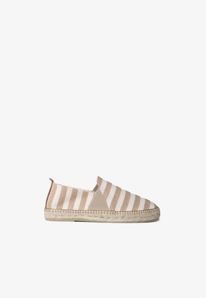 Μπεζ και λευκά ριγέ εσπαντρίγιες slip-on με σόλα από υλικό jute, διαθέτουν μαλακό επάνω μέρος από ύφασμα και μινιμαλιστικές σχεδιαστικές λεπτομέρειες.