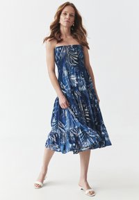 Rochie albastră fără bretele, cu un imprimeu floral, design în straturi și tiv ondulat. Material neted cu o siluetă fluidă și un luciu subtil.