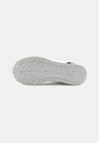 Witte gestructureerde zool van een schoen, met een robuust profiel voor betere grip, een gladde gebogen neus en versterkte randen.