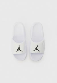 Bele sandale bele z teksturirano podplat, s črnim Jumpman logotipom na belem traku. Gladek material z odprtim dizajnom za prste.