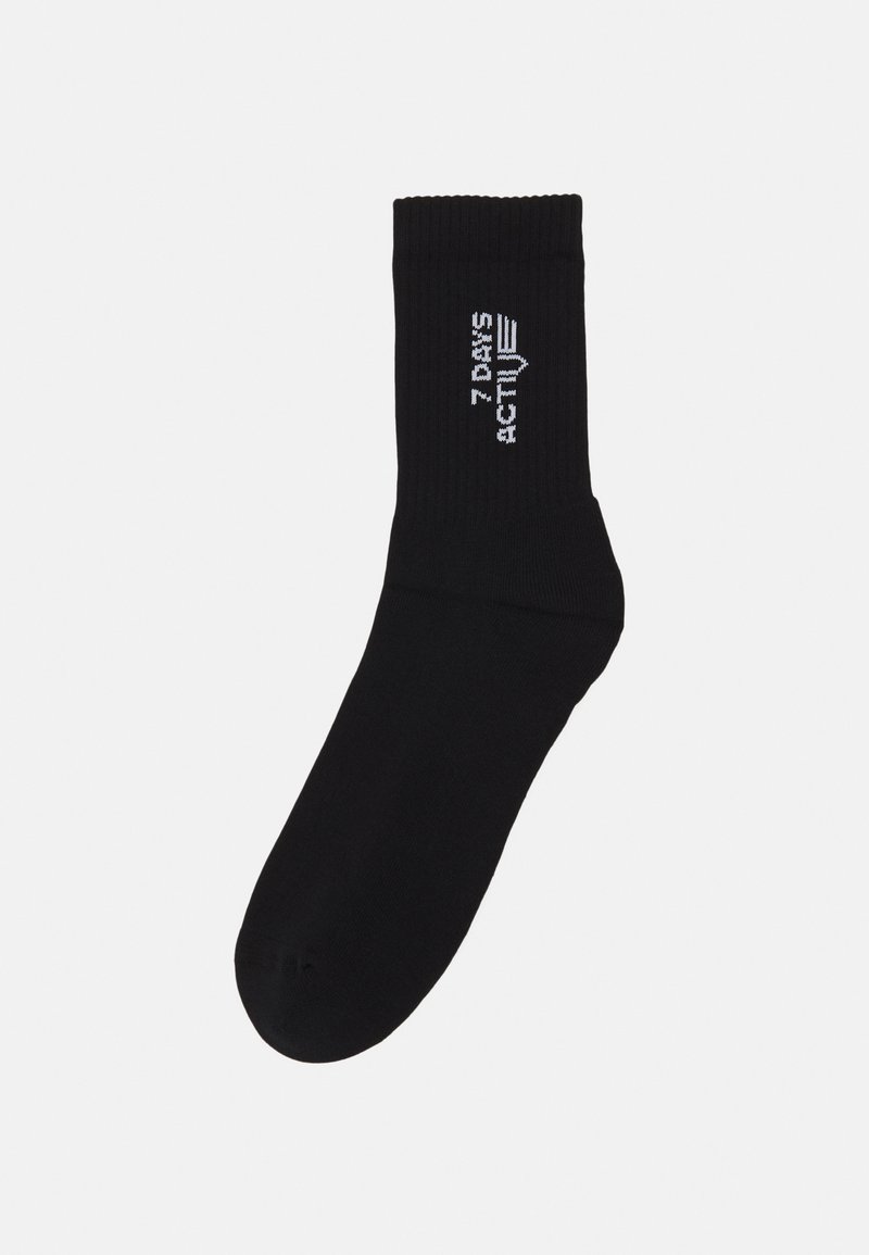 Sock de color negro con textura acanalada, que presenta el texto blanco "7 DAYS ACTIVE" en el lateral. Ajuste estándar con punta y puño reforzados.