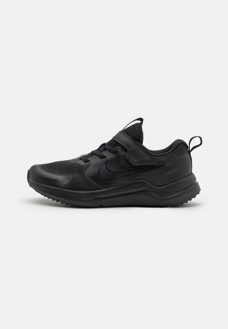 Chaussure de sport noire avec une tige en mesh, une semelle en caoutchouc et une sangle à velcro. Présente un bout arrondi et des détails texturés sur la semelle.