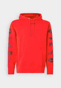 Röd huvtröja med känguruficka, med svarta tryckta grafik och "NIKE"-logotyp på framsidan och längs ärmarna.