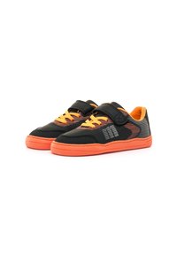 Baskets noires et orange pour enfants avec des bandes Velcro, des lacets orange, des côtés à motifs et des semelles orange vif sur un fond blanc.