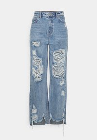 Blå høye midjejeans laget av denim, med store slitte lapper, rå kant, og en løs passform med sidelommer ved ankler.