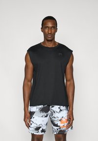 Haut de sport noir sans manches avec un col rond et un logo discret ; associé à un short à motif en gris, noir et touches d'orange.