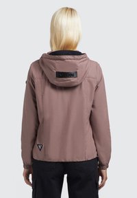 Hellrosa Jacke mit Kapuze, ausgestattet mit elastischen Bündchen und einem schwarzen Etikett auf der Rückseite. Glatte Textur, verkürztes Design und seitliche Logodetails.