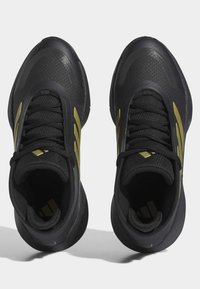 Scarpe sportive nere con una tomaia texturizzata, caratterizzate da accenti e lacci dorati, e una suola imbottita. La vista dall'alto mostra un design simmetrico.
