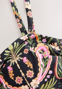 Schwarzer Stoff mit mehrfarbigem Blumen- und Paisleymuster auf einem Badeanzugoberteil mit verstellbarem Träger mit goldfarbenem Schieber.