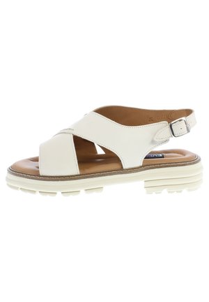 White leather sandal with cross-strap design, adjustable ankle buckle, and a cushioned brown insole. Features a textured rubber sole.