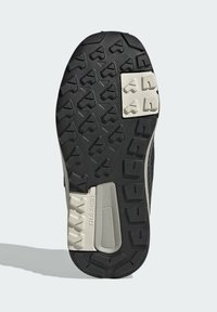 Suela de zapato de goma negra con tracción texturizada; cuenta con una almohadilla de tracción de color gris claro y patrones moldeados para una mejor adherencia.