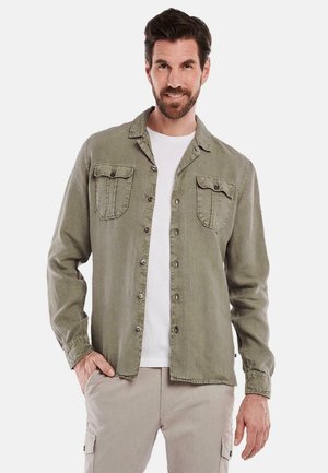 Olivgrüne Hemdjacke mit zwei Brusttaschen, langen Ärmeln und lockerer Passform. Der Stoff hat eine glatte und leichte Textur.