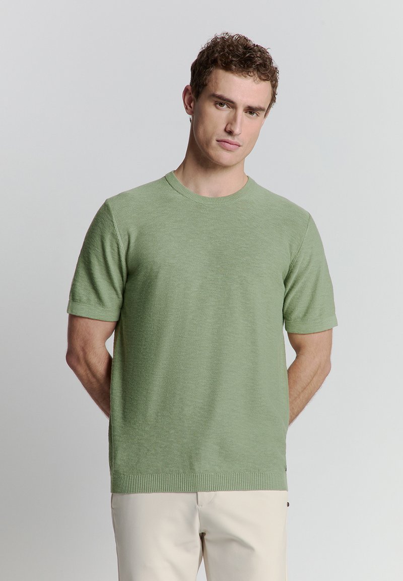 Lichtgroene sweater met korte mouwen en een ronde hals, gemaakt van een zacht, gestructureerd materiaal. Bevat een geribbelde onderrand en manchetten.