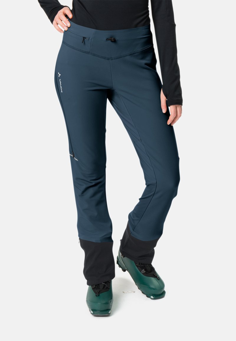 Dunkelblaue Skihosen aus leichtem Stoff mit hohem Bund, seitlichen Reißverschlusstaschen und integrierten Schneegamaschen an den Knöcheln.