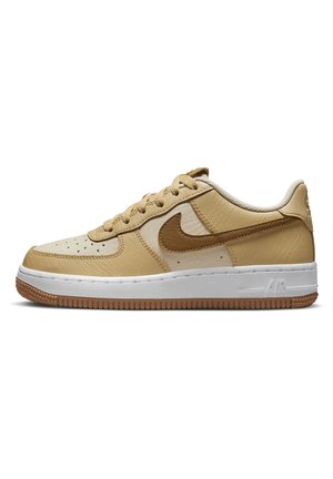 Baskets basses en cuir beige et marron avec semelle blanche et bande de roulement marron, avec perforations sur le bout et logo Swoosh cousu sur le côté.