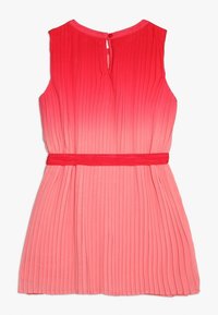 Pliseerattu mekko, jossa liukuvärjätyt vaaleanpunaiset sävyt. Mekossa on hihaton malli, pyöreä pääntie ja punainen vyö vyötäröllä. Selässä pieni avonainen leikkaus.