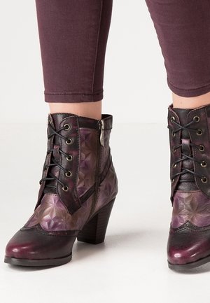 Stiefel aus lila und schwarzem Leder mit einem strukturierten geometrischen Muster, Schnürung vorne, seitlichem Reißverschluss und klobigem Absatz.