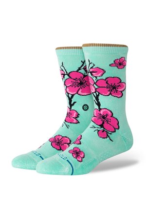 Calcetines verde menta con un patrón floral de flores de cerezo rosas con contornos negros, talón texturizado y puño acanalado en la parte superior.