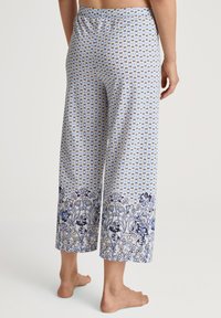 Blauwe en witte gebloemde pyjamabroek met een elastische tailleband, met een bloemmotief aan de onderkant en een losse, ruime pijp.