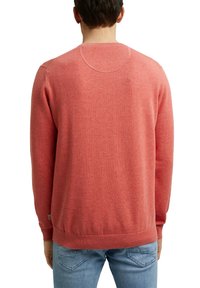 Luftiger, runder Hals Pullover in Koralle mit gerippten Bündchen und Saum, der eine glatte Stricktextur und dezente Nähte an den Schultern aufweist.
