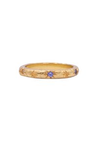 Anello in oro con motivi a stella incisi e due piccole gemme viola, con una finitura liscia e lucida.