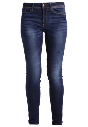 Jeans skinny en denim bleu foncé avec cinq poches, une fermeture éclair et un bouton. Texture fine avec de légers détails de décoloration sur les cuisses.