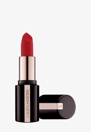 Rouge à lèvres rouge avec un bâton contourné, logé dans un cylindre noir avec une bande métallisée plaquée or et le nom de la marque embossé sur le côté.