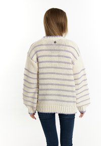 Brede gebreide trui in crèmekleur met paarse horizontale strepen, oversized fit, geribbelde manchetten en onderkant, met een knoopdetail op de achterkant.