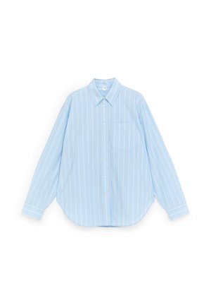 Camisa de manga larga azul claro con rayas verticales blancas y un bolsillo en el pecho, extendida sobre un fondo blanco.