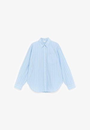 Camisa de manga larga azul claro con rayas verticales blancas y un bolsillo en el pecho, extendida sobre un fondo blanco.